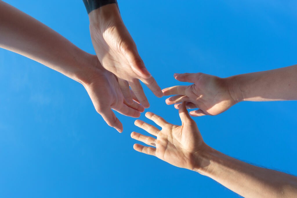 Hands reaching towards each other.